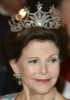 an older woman wearing a tiara and smiling at the camera