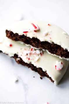 two pieces of chocolate cake with white frosting and candy canes on the top