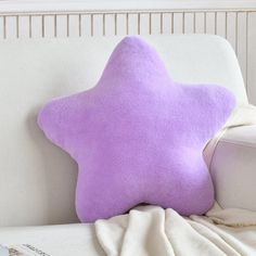 a purple star pillow sitting on top of a white couch