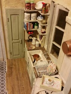 a small kitchen with an old fashioned sink and cupboards in the corner, filled with dishes