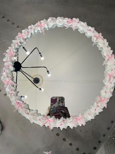 an umbrella decorated with pink and white flowers is seen from above, in the middle of a room