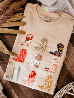 a child's t - shirt with different designs on it and some feathers next to it