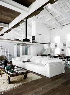 an image of a living room with white furniture and wood flooring on the walls