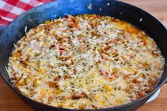 a casserole dish with meat and cheese in a pan on a wooden table