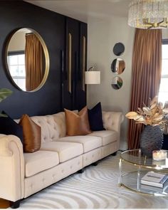 a living room filled with furniture and a large mirror on the wall above it's windows