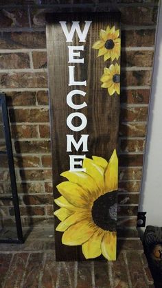 a welcome sign with sunflowers painted on it