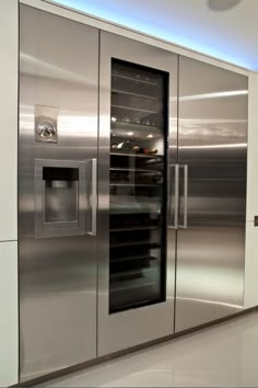 a stainless steel refrigerator in a kitchen with glass doors and shelves on the front side