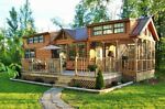 a large house sitting in the middle of a lush green field next to a forest