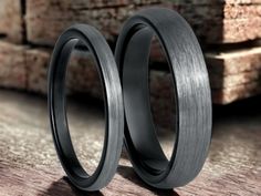 two black wedding rings sitting next to each other