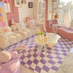 the living room is decorated in pastel colors and has pink walls, checkered rugs, white couches, and teddy bears