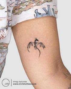 a woman's leg with a small dragon tattoo on the left side of her thigh