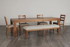 a wooden table with four chairs and a bench next to it on a hard wood floor