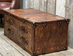 an old trunk sitting on the floor next to a chair