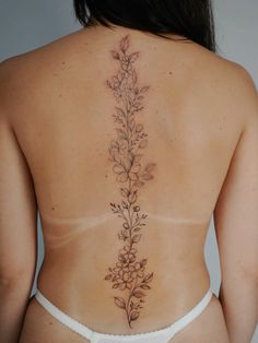 the back of a woman's body with flowers on her ribs and bottom part