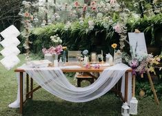 a table with flowers and candles on it in front of an outdoor setting for a wedding