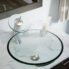 a bathroom sink with a glass bowl and chrome faucet on it's side