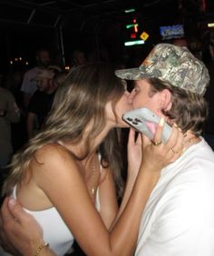 a man kissing a woman on the phone at a party