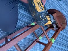 a person is using a drill to fix a piece of furniture