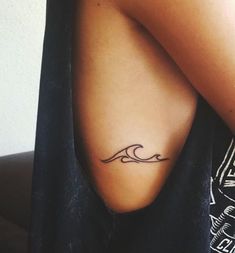 a woman's arm with a tattoo on it that has a wave in the middle