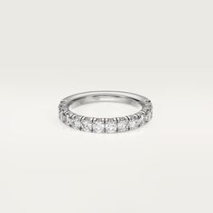 a white gold wedding band with five round diamonds on the top and bottom, set in 18k white gold