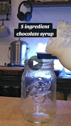 a person pouring milk into a glass jar