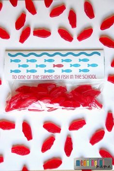 red fish in the school candy wrapper on a white table with blue and pink background