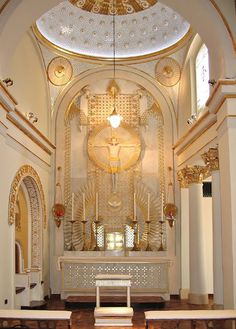 the inside of a church with white and gold decorations