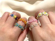 two woman's hands with colorful beaded rings