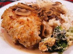 a white plate topped with meat and veggies covered in gravy