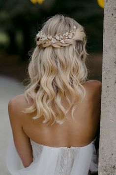 the back of a woman's head wearing a white dress and a flower crown