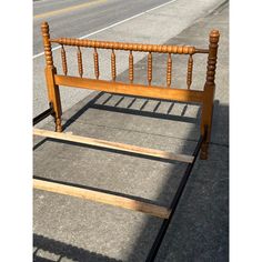 a wooden bed frame sitting on top of a sidewalk