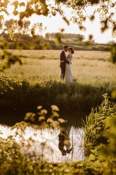 a bride and groom standing in the middle of a field