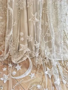 white sheer curtains with stars and beads on them