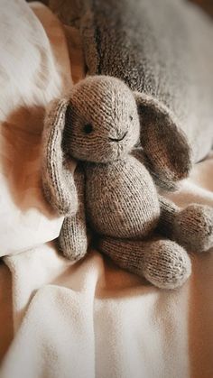 two stuffed animals sitting on top of a bed