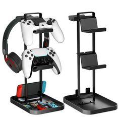 two video game controllers are on display in front of a phone holder and shelf with earphones