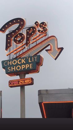 a neon sign that says stop and check it shoppe on top of a building