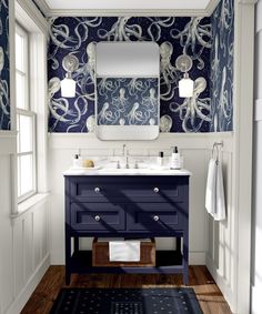 a bathroom with an octopus wallpaper and blue vanity, along with a rug on the floor