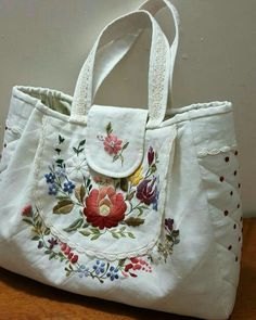 a white purse with embroidered flowers on it