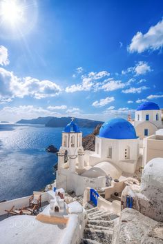 blue and white buildings overlooking the ocean on a sunny day