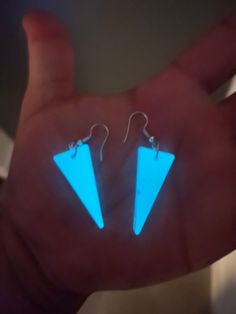 glow in the dark earrings with small triangle shaped blue lights on it's ear wires