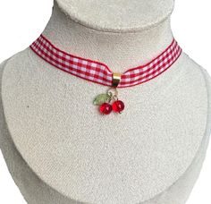 Cherry Gingham Ribbon Choker Step back into the 50s with this adorable cherry choker, perfect for adding a playful retro touch to your look. The red and white gingham ribbon pairs beautifully with the delicate cherry charm, giving your outfit a whimsical, yet elegant feel. The golden clasp and extender chain allow for adjustable length and a comfortable fit. *Materials: Fabric ribbon, metal clasp, glass beads *Size: Adjustable length *Design: Vintage-inspired with a minimalist cherry pendant Ideal for lovers of retro style, vintage accessories, or anyone looking for a unique piece to complete their everyday or special occasion outfits! Cupid Core, Cherry Choker, Cherry Pendant, Fabric Choker, Retro Cottage, Cherry Charm, Choker Handmade, Ribbon Choker, Cottage Fairy