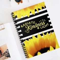 a spiral notebook with the words radiate, kindness and light on it