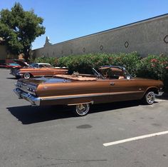 several classic cars parked in a parking lot