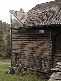 an old log cabin with stone steps leading up to it