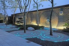 an outdoor area with trees, rocks and lights