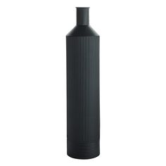 a large black vase sitting on top of a white floor next to a tall bottle