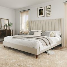 a large bed sitting on top of a wooden floor next to a dresser and mirror