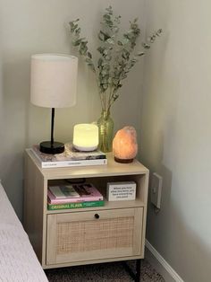 a nightstand with books and a lamp on it