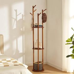 a bedroom with a bed, plant and wooden floor standing shelf on the wall next to it