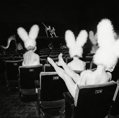 two women in bunny ears are sitting on the chairs and one woman is laying down